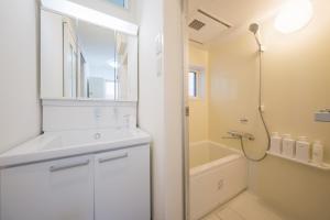 a white bathroom with a shower and a sink at Felice Haneda in Tokyo +42 photos