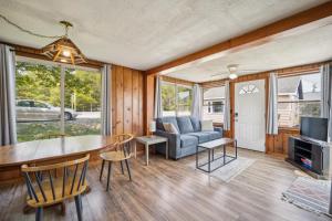 ein Wohnzimmer mit Tisch und Couch in der Unterkunft One bedroom cottage on the beach in Oscoda