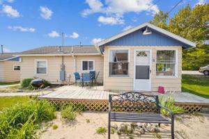 ein Haus mit einer Bank davor in der Unterkunft One bedroom cottage on the beach in Oscoda