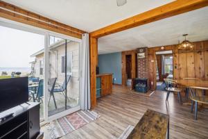 ein Wohnzimmer mit einer großen Glasschiebetür in der Unterkunft One bedroom cottage on the beach in Oscoda