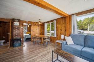 ein Wohnzimmer mit einem blauen Sofa und einem Tisch in der Unterkunft One bedroom cottage on the beach in Oscoda + 11 Fotos
