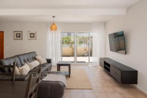 ein Wohnzimmer mit Sofa und Fernseher in der Unterkunft Moradia Felicidade Rocha PXO by An Island Apart in Porto Santo