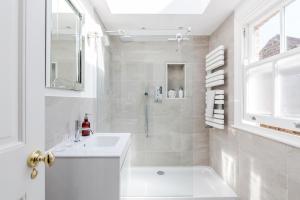 a white bathroom with a sink and a shower at Cresswell Lodge in Richmond +40 photos