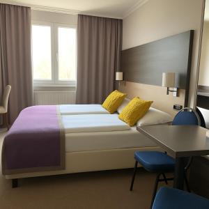 A bed or beds in a room at Arion Cityhotel Vienna