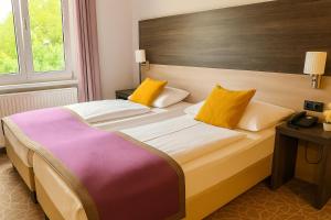 A bed or beds in a room at Arion Cityhotel Vienna