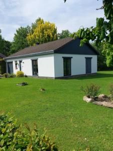 a white and black house with a yard at La Casa Bianca in Lierneux