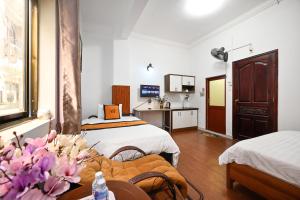 a hotel room with two beds and a table at A&E Guesthouse in Ho Chi Minh City