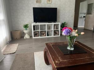 a living room with a vase of flowers on a coffee table at Teijo's Cozy House in Teijo