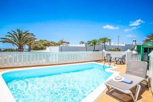 a swimming pool with a chair and a table at Casa Sussa in Tías