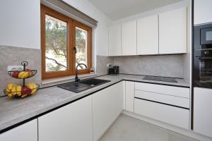 a kitchen with white cabinets and a bowl of fruit on the counter at Apartment Ante in Bibinje