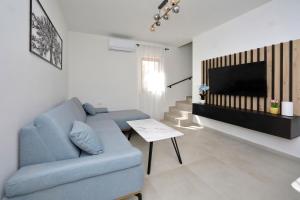 a living room with a blue couch and a tv at Apartment Ante in Bibinje