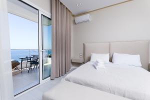 a bedroom with a white bed and a balcony at Villa Christianna Free Parking in Vlorë