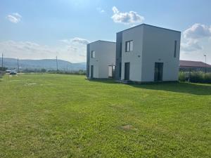two white buildings in a field of grass at Zen Residence in Curtea de Argeş