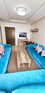 Una sala de estar con dos sofás azules y una mesa. en Luxury Pearl of Agadir, en Agadir