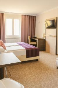 A bed or beds in a room at Arion Cityhotel Vienna