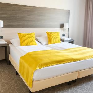 A bed or beds in a room at Arion Cityhotel Vienna