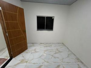 an empty room with a door and a window at Acomodação COP30 in Ananindeua