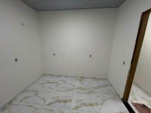 a room with white walls and a marble floor at Acomodação COP30 in Ananindeua