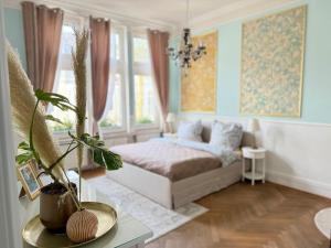 a bedroom with a bed and a table with plants at Luxury 5BR City Villa - Chic & Spacious - Families in Oldenburg