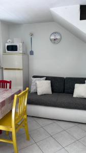 a living room with a couch and a yellow chair at Old Town Primošten in Primošten