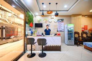 a woman standing behind a counter in a store at A&E Guesthouse in Ho Chi Minh City