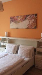 a bedroom with a bed with a painting above it at Balaton Vendégház Keszthely in Keszthely