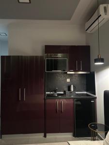 a kitchen with brown cabinets and a sink at CROSS PLAZA in Stavros +26 photos
