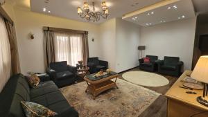 a living room with a couch and chairs and a table at Duplex in El Sherouk next to Madinty دوبلكس بحديقة خاصة مدينة الشروق in Madīnat ash Shurūq