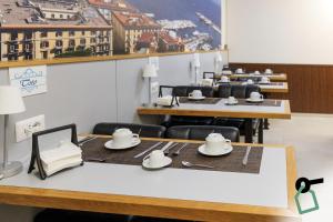 a dining room with tables and chairs with plates and cups at Botanique Napoli - 4 Design Rooms in Naples