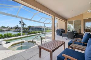 マルコ・アイランドにあるThe Seahorse House I Wide Views on Tip Lot Minutes from the Gulfのパティオ(プール、テーブル、椅子付)