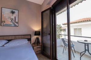 ペフコホリにあるK apartmentsのベッドルーム(ベッド1台、テーブル付)、バルコニーが備わります。