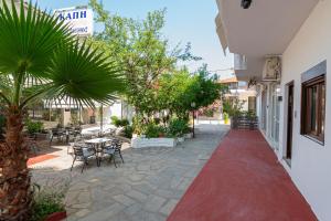 ペフコホリにあるK apartmentsのテーブルと椅子、そして赤いカーペットが敷かれたパティオ