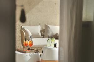 a living room with a couch and two tables with drinks at Masseria Borgo Sentinella in Torre dell'Orso