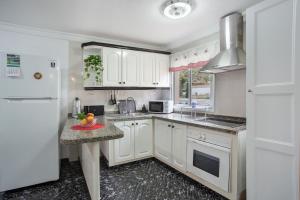 una cocina con armarios blancos y una bandeja de fruta en la barra en Casa Haroldo, en Candelaria