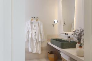 a bathroom with a white robe hanging on a wall at Masseria Borgo Sentinella in Torre dell'Orso