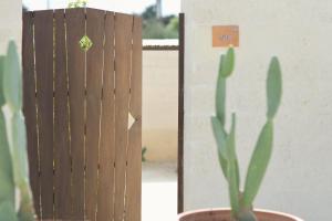 a plant in a pot next to a wooden fence at Masseria Borgo Sentinella in Torre dell'Orso