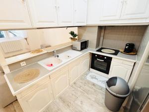 a small kitchen with a sink and a microwave at Appart Hotel 23 - Le Cocon Creusois 1 in Guéret
