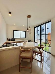 a kitchen with a table and chairs in a room at Bukawa Residences Balangan in Jimbaran