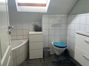 a bathroom with a toilet and a tub and a sink at 3-room apartment with terrace and carport in Filderstadt in Filderstadt +13 photos