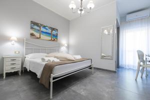 una camera da letto bianca con un letto e un tavolo di Bed and Breakfast Arcobaleno a Peschici