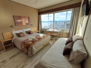 a hotel room with two beds and a large window at Aires de Bariloche in San Carlos de Bariloche