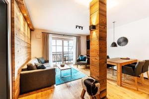 a living room with a couch and a table at Luxury Apartment Murmeltier mit 4-Sterne Hotelanbindung in Oberstaufen