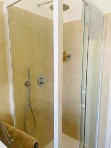 a bathroom with a shower with a glass door at Baveno Lakeview Escape in Baveno +13 photos