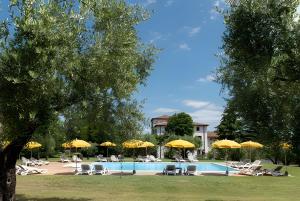 una piscina con sillas y sombrillas en Mono Garden Colombare Teboi, en Lazise