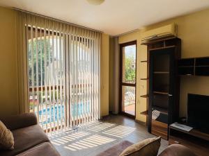 a living room with a couch and a large window at KALIA C9 One Bedroom Apartment in Sunny Beach