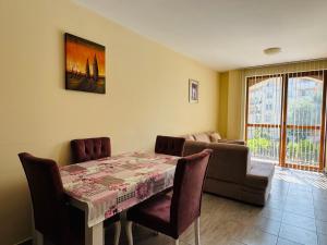 a dining room with a table and a couch at KALIA C9 One Bedroom Apartment in Sunny Beach