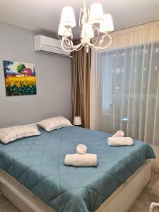 a bedroom with a blue bed with two towels on it at Sunrise Luxury Sauth Bay in Varna City +45 photos
