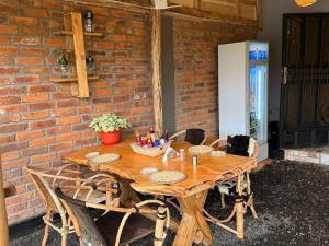 una mesa de madera con sillas y una pared de ladrillo en Baraka Home, en Arusha 25 fotos más