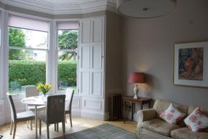 a living room with a table and a couch at Victorian Apartment with car parking in driveway, Murrayfield in Edinburgh