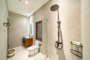 a bathroom with a toilet and a glass shower at Private Pool - Serene Vibes - Perfect Bali Escape - Your home 3BDR Villa in Sanur +10 photos